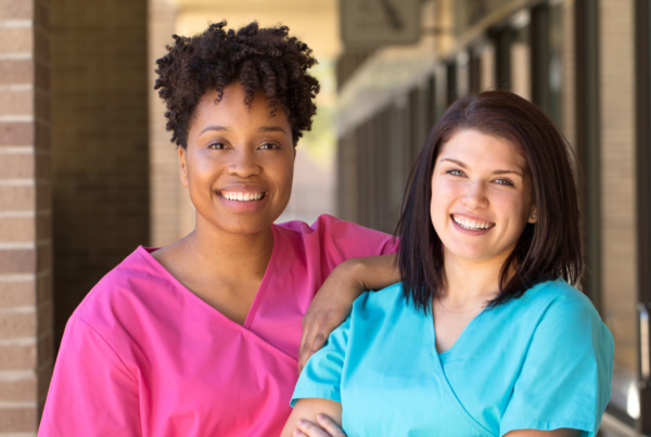 Two nurses smile standing next to each other #joyintheworkplace